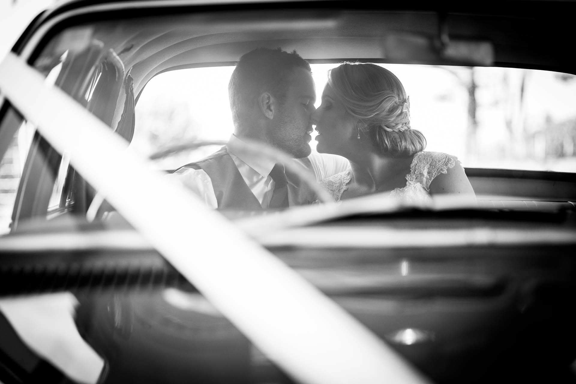 Bride-and-groom-black-white-car-kiss