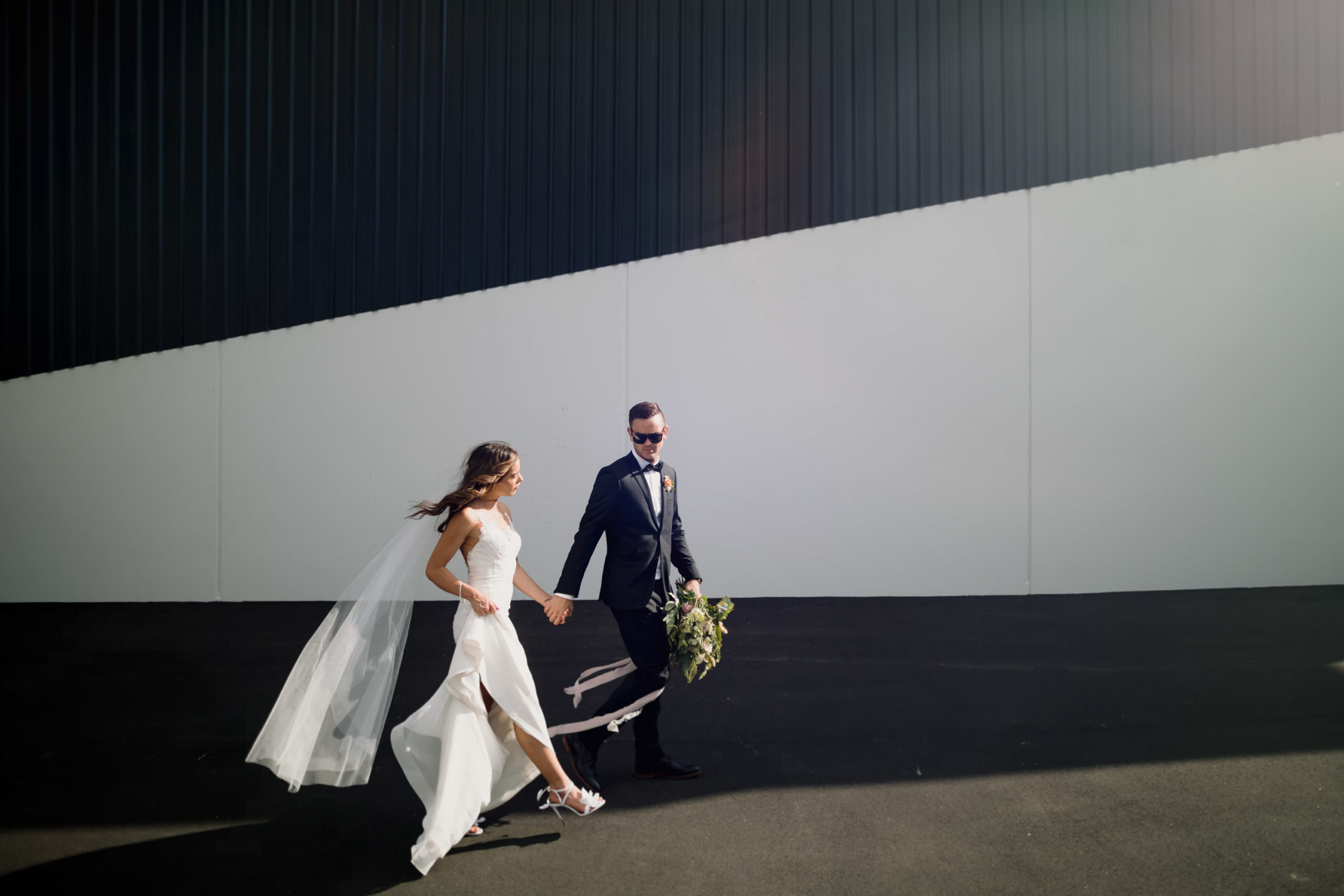 Waikato wedding photography bride and groom on black white wall