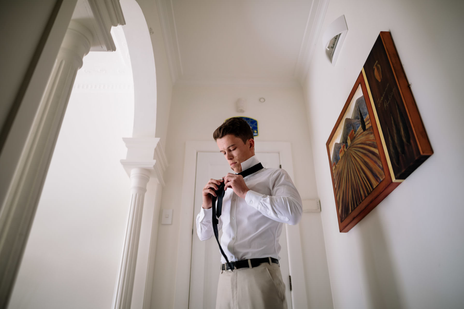 Groom learning how to tie a tie
